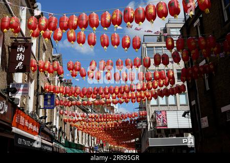 Lanterne cinesi rosse e dorate si stagliarono su Lisle St a Chinatown, Londra, Regno Unito. Foto Stock