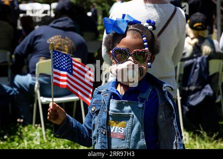 210601 -- NEW YORK, 1 giugno 2021 -- Una ragazza tiene una bandiera in un servizio commemorativo dopo la parata del 154° Memorial Day di Brooklyn e la galleria di automobili nel quartiere di Brooklyn di New York, negli Stati Uniti, il 31 maggio 2021. I newyorkesi lunedì hanno commemorato la festa del Memorial Day degli Stati Uniti con incontri e spettacoli per onorare i membri del servizio militare e celebrare l'arrivo dell'estate. U.S.-NEW YORK-MEMORIAL DAY PARADE MICHAELXNAGLE PUBLICATIONXNOTXINXCHN Foto Stock