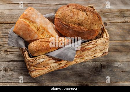 Varietà di pane assortite in un incantevole cestino, pronto per essere gustato Foto Stock