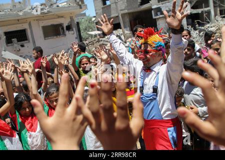 210602 -- PECHINO, 2 giugno 2021 -- Un volontario palestinese vestito da clown interagisce con i bambini, sulle macerie di case distrutte in un attacco aereo israeliano, nella città settentrionale di Beit Hanoun, nella Striscia di Gaza, il 24 maggio 2021. Foto di /Xinhua Portraits of May 2021 RizekxAbdeljawad PUBLICATIONxNOTxINxCHN Foto Stock