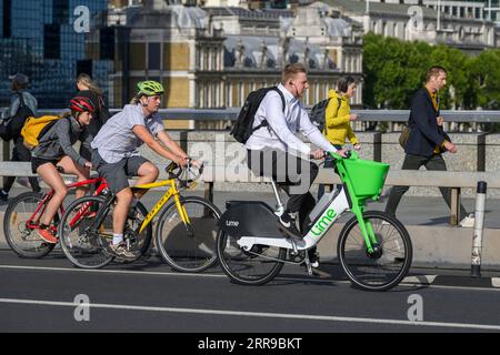 Un uomo che viaggia su una bici elettrica Lime a noleggio durante l'ora di punta. , Londra, Regno Unito. 17 luglio 2023 Foto Stock