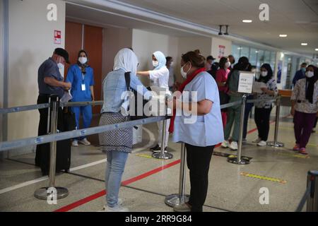 210615 -- CASABLANCA MAROCCO, 15 giugno 2021 -- un membro dello staff dell'aeroporto R, Front controlla il risultato del test PCR COVID-19 di un viaggiatore all'aeroporto internazionale Mohammed V di Casablanca, Marocco, il 15 giugno 2021. Il Marocco ha allentato le restrizioni ai confini e ha permesso ai passeggeri internazionali di entrare nel paese a partire da martedì prima della stagione turistica. MAROCCO-CASABLANCA-VIAGGIATORI-VOLI Xinhua PUBLICATIONxNOTxINxCHN Foto Stock