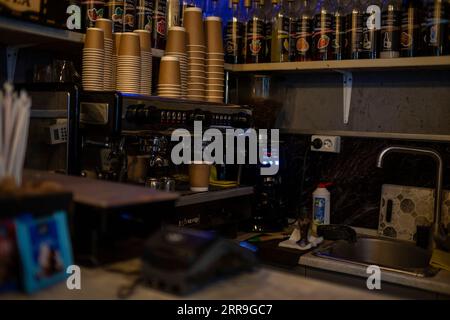 Una piccola azienda di caffè. Prepara espresso americano con piatti da  asporto. Un barista professionista prepara il caffè in una macchina per il  caffè a base di carruba. Lavoro preferito in Foto