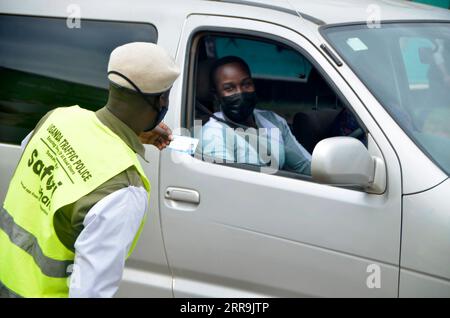 210620 -- KAMPALA, 20 giugno 2021 -- Un agente della polizia stradale controlla i documenti in un check-point a Kampala, Uganda, 19 giugno 2021. Venerdì il presidente ugandese Yoweri Museveni ha annunciato una serie di misure volte a contenere la rapida diffusione del nuovo coronavirus mentre il paese sta vivendo una seconda ondata. Foto di /Xinhua UGANDA-KAMPALA-ANTI-COVID-19-MEASURES NicholasxKajoba PUBLICATIONxNOTxINxCHN Foto Stock