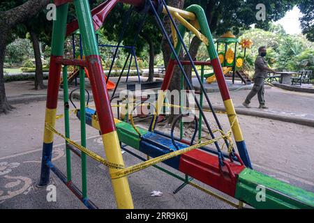 210620 -- DENPASAR, 20 giugno 2021 -- un ufficiale cordoni fuori da un parco giochi con un nastro di cautela al Puputan Bandung Park a Denpasar, Bali, Indonesia, 20 giugno 2021. L'Indonesia domenica ha registrato 13.737 casi recentemente confermati di COVID-19 nelle ultime 24 ore, segnando il picco giornaliero più alto dal gennaio 30 e portando il totale a 1.989.909, ha detto il Ministero della salute. Foto di /Xinhua INDONESIA-DENPASAR-COVID-19-RESTRICTION Bisinglasi PUBLICATIONxNOTxINxCHN Foto Stock