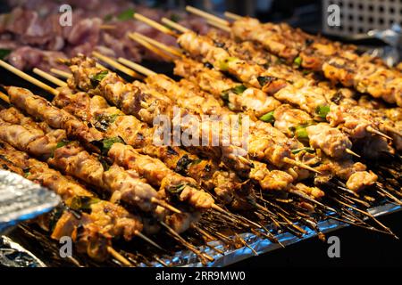 Grigliate con spiedino di carne e kebab presso la tradizionale bancarella del mercato notturno, delizioso cibo di strada in Corea del Sud. Foto Stock
