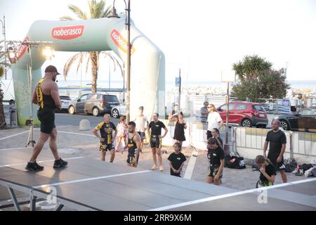 Le immagini raffigurano una lezione animata di kickboxing per bambini in Italia in occasione di un evento pubblico. Ai giovani partecipanti viene mostrato di essere attivamente impegnati in esercizi. Foto Stock