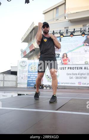 Le immagini raffigurano una lezione animata di kickboxing per bambini in Italia in occasione di un evento pubblico. Ai giovani partecipanti viene mostrato di essere attivamente impegnati in esercizi. Foto Stock