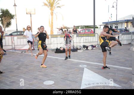 Le immagini raffigurano una lezione animata di kickboxing per bambini in Italia in occasione di un evento pubblico. Ai giovani partecipanti viene mostrato di essere attivamente impegnati in esercizi. Foto Stock