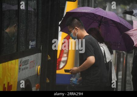 210712 -- PECHINO, 12 luglio 2021 -- la gente sale su un autobus sotto la pioggia nel distretto di Haidian di Pechino, capitale della Cina, 12 luglio 2021. Secondo il dipartimento municipale per il controllo delle inondazioni, la capitale cinese Pechino è stata colpita da forti precipitazioni dalle 18:00, domenica con precipitazioni fino a 116,4 mm. Dalle 18:00 della domenica alle 9:00 del lunedì, Pechino ha registrato precipitazioni medie di 65,9 mm. Le aree urbane della città hanno riportato precipitazioni medie più alte di 79,9 mm. CINA-PECHINO-PRECIPITAZIONI PESANTI CN RenxChao PUBLICATIONxNOTxINxCHN Foto Stock