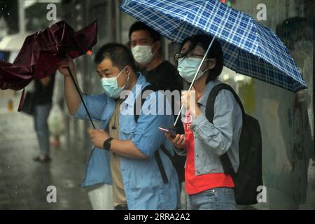 210712 -- PECHINO, 12 luglio 2021 -- la gente aspetta l'autobus sotto la pioggia presso una fermata dell'autobus nel distretto di Haidian di Pechino, capitale della Cina, 12 luglio 2021. Secondo il dipartimento municipale per il controllo delle inondazioni, la capitale cinese Pechino è stata colpita da forti precipitazioni dalle 18:00, domenica con precipitazioni fino a 116,4 mm. Dalle 18:00 della domenica alle 9:00 del lunedì, Pechino ha registrato precipitazioni medie di 65,9 mm. Le aree urbane della città hanno riportato precipitazioni medie più alte di 79,9 mm. CINA-PECHINO-PRECIPITAZIONI PESANTI CN RenxChao PUBLICATIONxNOTxINxCHN Foto Stock