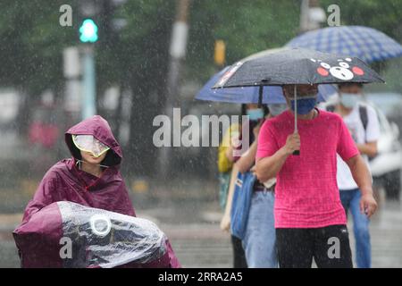 210712 -- PECHINO, 12 luglio 2021 -- la gente cammina sotto la pioggia su una strada nel distretto di Chaoyang di Pechino, capitale della Cina, 12 luglio 2021. Secondo il dipartimento municipale per il controllo delle inondazioni, la capitale cinese Pechino è stata colpita da forti precipitazioni dalle 18:00, domenica con precipitazioni fino a 116,4 mm. Dalle 18:00 della domenica alle 9:00 del lunedì, Pechino ha registrato precipitazioni medie di 65,9 mm. Le aree urbane della città hanno riportato precipitazioni medie più alte di 79,9 mm. CINA-PECHINO-PRECIPITAZIONI PESANTI CN JuxHuanzong PUBLICATIONxNOTxINxCHN Foto Stock