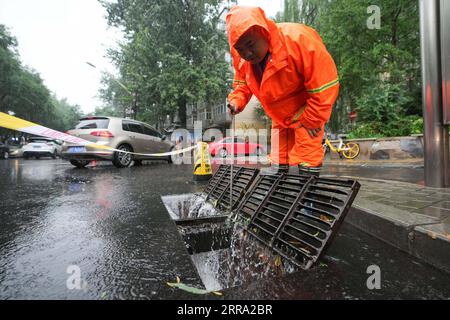 210712 -- PECHINO, 12 luglio 2021 -- Un lavoratore controlla il sistema di drenaggio su una strada nel distretto di Chaoyang di Pechino, capitale della Cina, 12 luglio 2021. Secondo il dipartimento municipale per il controllo delle inondazioni, la capitale cinese Pechino è stata colpita da forti precipitazioni dalle 18:00, domenica con precipitazioni fino a 116,4 mm. Dalle 18:00 della domenica alle 9:00 del lunedì, Pechino ha registrato precipitazioni medie di 65,9 mm. Le aree urbane della città hanno riportato precipitazioni medie più alte di 79,9 mm. CINA-PECHINO-PRECIPITAZIONI PESANTI CN JuxHuanzong PUBLICATIONxNOTxINxCHN Foto Stock