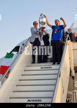 210712 -- ROMA, 12 luglio 2021 -- la foto scattata il 12 luglio 2021 mostra l'allenatore italiano Roberto Mancini L, il frontalino e giocatore Giorgio Chiellini R, che detiene il trofeo mentre i membri della squadra di calcio italiana arrivano all'aeroporto di Fiumicino dopo aver vinto la finale contro l'Inghilterra all'UEFA EURO 2020 a Roma, Italia. SPITALY-ROMA-UEFA EURO 2020-SQUADRA DI CALCIO ITALIANA STRINGER PUBLICATIONXNOTXINXCHN Foto Stock