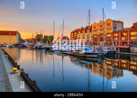 Marina sul fiume Motlawa al tramonto nella città di Danzica, Polonia. Yacht e barche a vela nel porto moderno con una capacità di 80 posti barca e sul lungomare Foto Stock