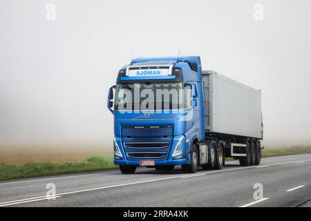 Semirimorchio Volvo FH blu del camion Transport Sjoman Oy Ab che si trova lungo l'autostrada 52 in una mattinata estiva nebbiosa. Salo, Finlandia. 25 agosto 2023. Foto Stock