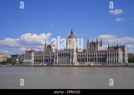 L'edificio neo-gotico del parlamento dall'altra parte del Danubio, progettato da Imre Steindl nel 1885, Budapest, Ungheria Foto Stock