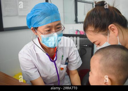 210720 -- URUMQI, 20 luglio 2021 -- il dottor Yu Lijuan, inviato dal comune di Pechino a lavorare a Kunyu, diagnostica un ragazzo paziente presso l'ospedale del popolo Kunyu nella città di Kunyu, nella regione autonoma dello Xinjiang Uygur della Cina nord-occidentale, 16 luglio 2021. Foto di /Xinhua Xinhua titoli: La Cina raccoglie risorse per aiutare lo Xinjiang a raggiungere una prosperità moderata HexDan PUBLICATIONxNOTxINxCHN Foto Stock