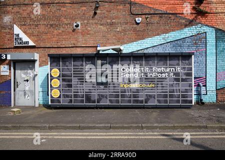 InPost o cassette postali, armadietti per pacchi o macchine automatiche per pacchi (APM) e pareti verniciate Liverpool Inghilterra Regno Unito Foto Stock