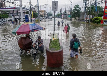 210724 -- PROVINCIA DI RIZAL, 24 luglio 2021 -- le persone si sono gettate nell'acqua alluvionale portata dalle pesanti piogge monsoniche nella provincia di Rizal, nelle Filippine, 24 luglio 2021. Le Filippine hanno evacuato più di 15.000 persone a Metro Manila e in alcune parti del paese in mezzo alla minaccia delle inondazioni, hanno detto le autorità di gestione delle catastrofi sabato. FILIPPINE-PROVINCIA DI RIZAL-INONDAZIONI MONSONICHE RouellexUmali PUBLICATIONxNOTxINxCHN Foto Stock