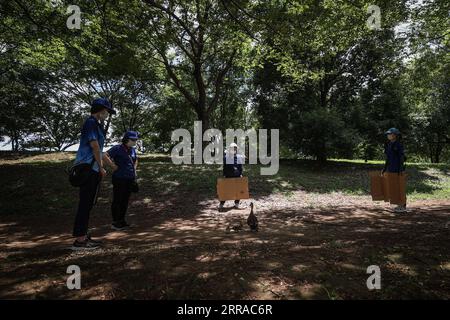 210725 -- SHIZUOKA, 25 luglio 2021 -- i membri del personale aiutano un uccello a rimanere fuori dal Fuji International Speedway durante l'evento ciclistico femminile su strada ai Giochi Olimpici di Tokyo 2020 a Shizuoka, Giappone, il 25 luglio 2021. TOKYO202020JAPAN-SHIZUOKA-OLY-CYCLING ROAD PanxYulong PUBLICATIONxNOTxINxCHN Foto Stock