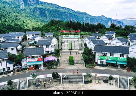 210726 -- QIANXI, 26 luglio 2021 -- foto aerea scattata il 24 luglio 2021 mostra una vista di un sito di trasferimento per alleviare la povertà al villaggio di Huawu a Xinren Miao Township, Qianxi City, provincia di Guizhou nella Cina sud-occidentale. Il villaggio di Huawu, pur vantando una cultura etnica unica di Miao e splendide viste sulle montagne con vasti corpi idrici, una volta aveva un tasso di povertà del personale fino al 63,6%. Approfittando del ricco patrimonio culturale e naturale, il governo locale ha avviato un progetto di area panoramica come misura mirata per scongiurare la povertà e stimolare il turismo costruendo un galler lungo chilometri Foto Stock
