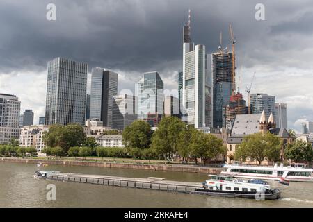 Una chiatta passa davanti ai grattacieli sulla riva del fiume meno a Francoforte sul meno, Germania Foto Stock