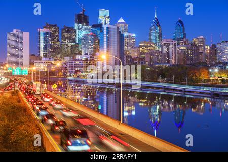 Filadelfia, Pennsylvania, USA, skyline del centro cittadino sul fiume Schuylkill con traffico notturno. Foto Stock