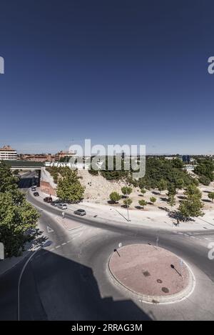 Vista di una rotatoria su una strada vicino a un cavalcavia sotto una tangenziale Foto Stock