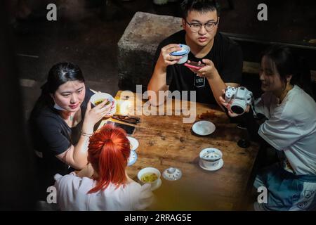 210730 -- CHONGQING, 30 luglio 2021 -- le persone chiacchierano mentre bevevano un tè al Communications Teahouse, a Chongqing, nella Cina sud-occidentale, 26 luglio 2021. Chen Anjian, 62 anni, insegnante di pittura ad olio presso l'Istituto di Belle Arti di Sichuan, frequenta la Chongqing Communications Teahouse da più di 20 anni. Fondata nel 1987, la Communications Teahouse è ora l'unica vecchia casa da tè di Chongqing che ha mantenuto lo stile originale degli anni '1970 e '80 E' uno dei punti di riferimento culturali chiave di Chongqing, ed e' visitato da migliaia di amanti del te' ogni giorno. La Communications Teahouse è lo spazio abitativo di CH Foto Stock