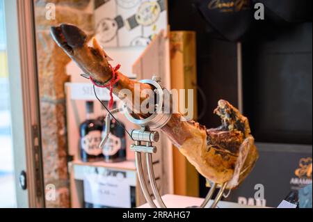 Coscia di suino serrano Iberian Saled Jamon in stand in macelleria spagnola da vicino Foto Stock