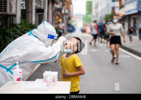 210810 -- ZHANGJIAJIE, 10 agosto 2021 -- Un operatore medico preleva un campione di tampone da un ragazzo per il test degli acidi nucleici COVID-19 a Zhangjiajie, Cina centrale, provincia di Hunan, 10 agosto 2021. Dalla recente rinascita della COVID-19 a Zhangjiajie dal luglio 29, la città ha riportato 53 casi confermati trasmessi localmente e tre portatori asintomatici sono attualmente sotto osservazione medica. CHINA-HUNAN-ZHANGJIAJIE-COVID-19-MASS TESTING CN CHENXSIHAN PUBLICATIONXNOTXINXCHN Foto Stock