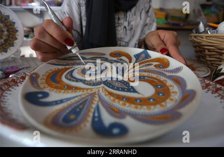 210810 -- JENIN, 10 agosto 2021 -- Diaa Sbehat decora un piatto di ceramica con dipinti di motivi islamici nel suo laboratorio nella città di Jenin, 10 agosto 2021. Sbehat si era laureata alla al-Quds Open University con una laurea in tecnologia dell'informazione e della comunicazione prima di iniziare a realizzare decorazioni in ceramica. Si guadagna da vivere vendendo le sue opere tramite i social media. Foto di /Xinhua MIDEAST-JENIN-CERAMIC ART NidalxEshtayeh PUBLICATIONxNOTxINxCHN Foto Stock