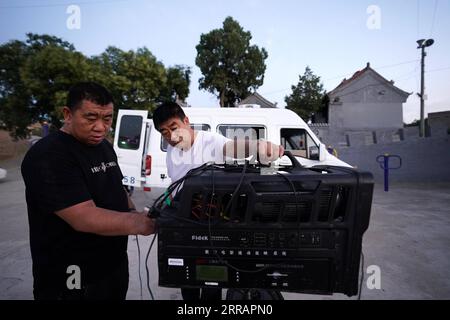 210813 -- TAIYUAN, 13 agosto 2021 -- Xue Xiaogang L si prepara a proiettare un film al pubblico nel villaggio di Gaojiayan, Sanjiao Township della contea di Liulin, provincia dello Shanxi della Cina settentrionale, 10 agosto 2021. Nel 1975, Sanjiao Township ha istituito un team di proiezione cinematografica. Liu Bufei e Liu Dengzhao, entrambi cinefili fin dall'infanzia, si unirono alla squadra e divennero proiettisti rurali. Nel 2007, il team è diventato una troika quando si è Unito al proiettile di seconda generazione Xue Xiaogang, che aveva visto film all'aperto nel villaggio mentre cresceva. Nel corso degli anni, il team di proiezione, per innumerevoli volte ha guidato al Foto Stock