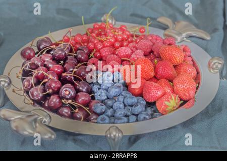 Rigenera frutti di bosco freschi assortiti su un grande vassoio d'argento per una festa gustosa Foto Stock
