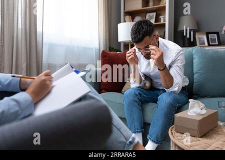 Psicologia degli affari. Una psicoterapeuta parla uno contro l'altro con un cliente maschio che è un lavoratore, un dipendente dell'azienda o un proprietario di piccole imprese, che è un unde Foto Stock