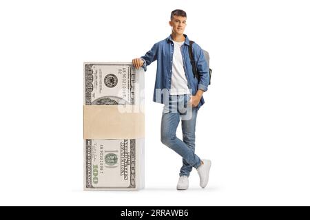 Studente maschio appoggiato su una pila di banconote da dollari isolati su sfondo bianco Foto Stock