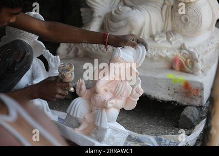 210818 -- KANGRA, 18 agosto 2021 -- un'opera artigianale su un idolo del dio indù con testa di elefante Ganesha in un laboratorio davanti al festival Ganesh Chaturthi a Kangra di Himachal Pradesh, India, 17 agosto 2021. Str/Xinhua INDIA-HIMACHAL PRADESH-KANGRA-FESTIVAL PREPARAZIONE JavedxDar PUBLICATIONxNOTxINxCHN Foto Stock