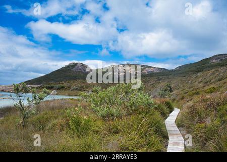 Passerella in legno attraverso una palude di acqua salata nella riserva naturale di Two Peoples Bay, vicino ad Albany, Australia Occidentale. Fine campo granito sullo sfondo. Foto Stock