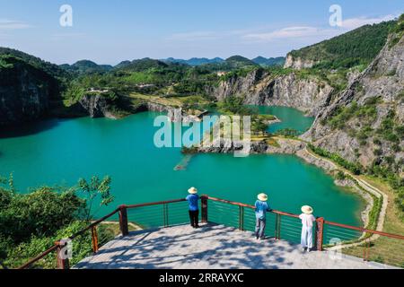 210823 -- CHONGQING, 23 agosto 2021 -- foto aerea scattata il 17 agosto 2021 mostra le persone che visitano il parco minerario di Tongluo Mountain nella città di Shichuan, distretto di Yubei di Chongqing, Cina sud-occidentale. La città di Shichuan, un tempo una delle principali cave di pietre calcaree, vide le sue foreste e le terre coltivabili distrutte dallo sfruttamento. Di fronte al deterioramento dell'ambiente, il governo locale ha chiuso la cava di Tongluo Mountain nel 2012. A partire dal 2016, sono stati realizzati progetti di restauro ecologico del monte Tongluo e l'ex cava è stata trasformata in un parco minerario. Con il miglioramento dell'ambiente, il Foto Stock