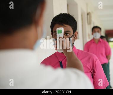 210825 -- AGARTALA, 25 agosto 2021 -- uno studente della scuola Netaji Subhas Vidyaniketan, ha controllato la temperatura prima di entrare in classe il primo giorno di riapertura delle scuole e dei college dopo il rilassamento nelle reiczioni COVID-19 ad Agartala, la capitale dello stato nord-orientale dell'India di Tripura, 25 agosto 2021. /Xinhua INDIA- AGARTALA -RIAPERTURA DELLE SCUOLE via PUBLICATIONxNOTxINxCHN Foto Stock