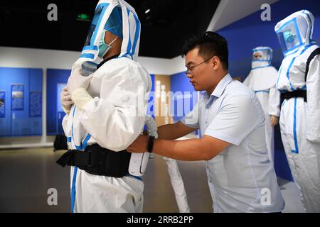 210827 -- ZHENGZHOU, 27 agosto 2021 -- Un membro dello staff indossa una tuta di protezione medica per l'aria condizionata sviluppata dal gruppo Tuoren a Changyuan, città di Xinxiang, provincia di Henan, Cina centrale, 26 agosto 2021. Il produttore cinese di materiali di consumo medicali Tuoren Group ha sviluppato una tuta protettiva medica a pressione positiva dell'aria condizionata che può fornire aria fresca per gli operatori sanitari che li indossano. La temperatura all'interno della tuta è regolabile tra 26 e 29 gradi Celsius. L'indumento non solo è sicuro ed efficace, ma rende anche più confortevole lavorare in estate. CHINA-HENAN-INNOVATION-COVI Foto Stock