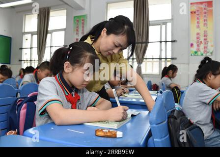 210909 -- HEFEI, 9 settembre 2021 -- Zhao Xun istruisce uno studente nella classe cinese presso la Luogang Primary School di Hefei City, provincia di Anhui nella Cina orientale, 8 settembre 2021. Zhao Xun, un insegnante di cinese della Luogang Primary School, anch'egli appassionato di maglieria, crea un club di maglieria e insegna ai suoi studenti il lavoro a mano durante il doposcuola. CHINA-ANHUI-HEFEI-AFTER-SCHOOL ACTIVITY CN ZHOUXMU PUBLICATIONXNOTXINXCHN Foto Stock