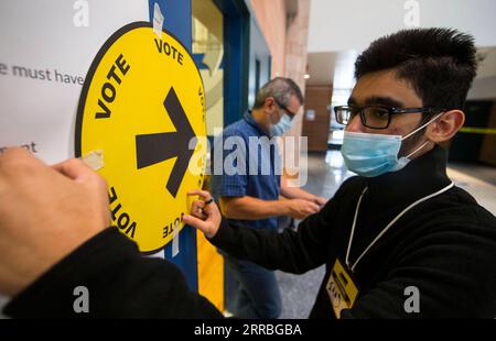 210921 -- MISSISSAUGA, 21 settembre 2021 -- un funzionario di informazione delle elezioni Canada registra un cartello con la freccia di voto fuori da una sede elettorale a Mississauga, Ontario, Canada, 20 settembre 2021. I canadesi si si dirigono ai sondaggi in tutto il paese lunedì per scegliere un primo ministro che formerà il prossimo governo federale dopo una campagna elettorale di 36 giorni in mezzo alla quarta ondata di COVID-19. Foto di /Xinhua CANADA-ONTARIO-MISSISSAUGA-44A ELEZIONE GENERALE-VOTA ZouxZheng PUBLICATIONxNOTxINxCHN Foto Stock