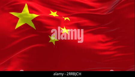 Primo piano della bandiera nazionale della Cina che sventola nel vento. Sfondo rosso, cinque stelle gialle. Il più grande simboleggia la guida del comunista cinese Foto Stock