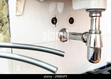 installazione di nuovi tubi flessibili dell'acqua in polietilene per il rubinetto sul lavandino (attenzione al sifone) durante l'installazione di una nuova alimentazione idrica in bagno Foto Stock