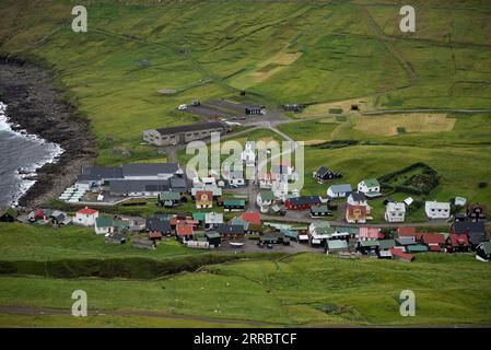 Il piccolo villaggio di Gjogv e la sua chiesa affollano il mare nell'angolo nord-est dell'isola di Eysturoy nelle Isole Faroe. Foto Stock