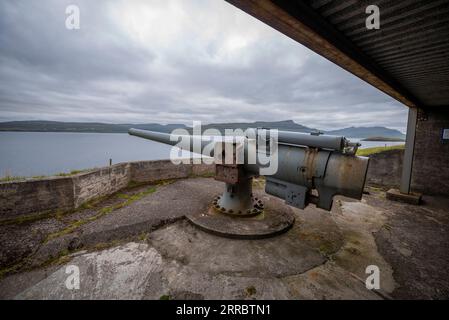 Un cannone britannico dell'era della seconda guerra mondiale per difendere Skalafirth al largo dell'isola di Eysturoy nelle Isole Faroe. Foto Stock