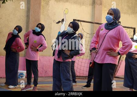 211010 -- CAIRO, 10 ottobre 2021 -- studenti che indossano maschere facciali fanno esercizi in una scuola media dopo mesi di chiusura a causa della COVID-19 al Cairo, Egitto, 10 ottobre 2021. Milioni di studenti scolastici e universitari hanno iniziato a frequentare fisicamente le lezioni per la prima volta in 18 mesi a partire da sabato in Egitto. Scuole e università hanno lanciato campagne di sensibilizzazione sanitaria per esortare gli studenti, il personale docente e i lavoratori a rispettare tutte le precauzioni contro la COVID-19, tra cui il mantenimento della distanza fisica e l'uso di maschere facciali. EGITTO-CAIRO-STUDENTI-RITORNO A SCUOLA AHMEDXGOMAA PUBLICATIONXNOTX Foto Stock