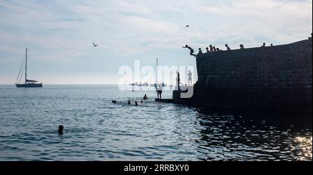 Brighton Regno Unito 7 settembre 2023 - i giovani saltano in mare a Brighton nel giorno più caldo dell'anno fino a quando le temperature hanno raggiunto di nuovo oltre 30 gradi in alcune parti del Regno Unito : Credit Simon Dack / Alamy Live News Foto Stock